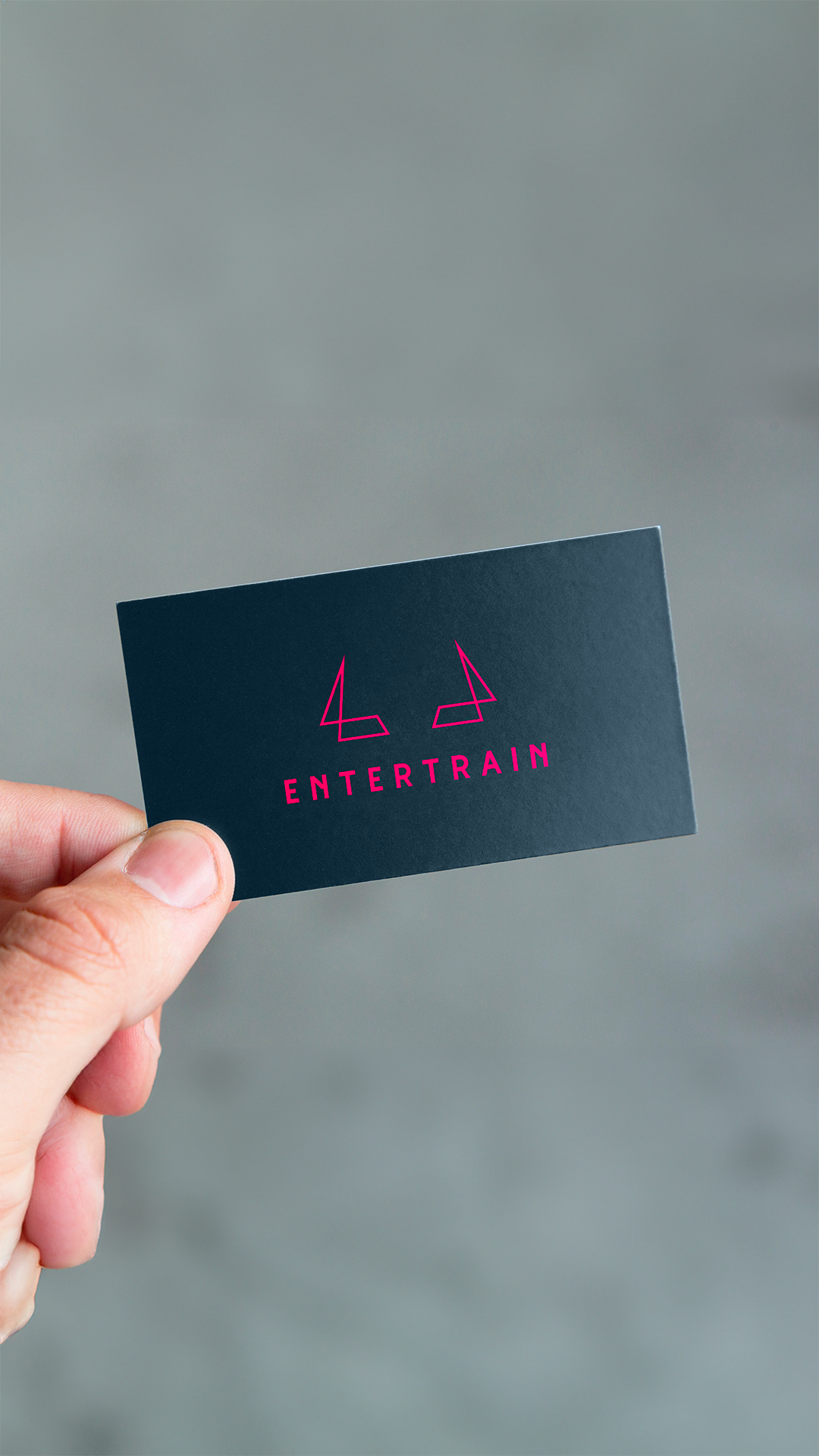 Une photo d'une main tenant la carte de visite de Entertrain coaching.